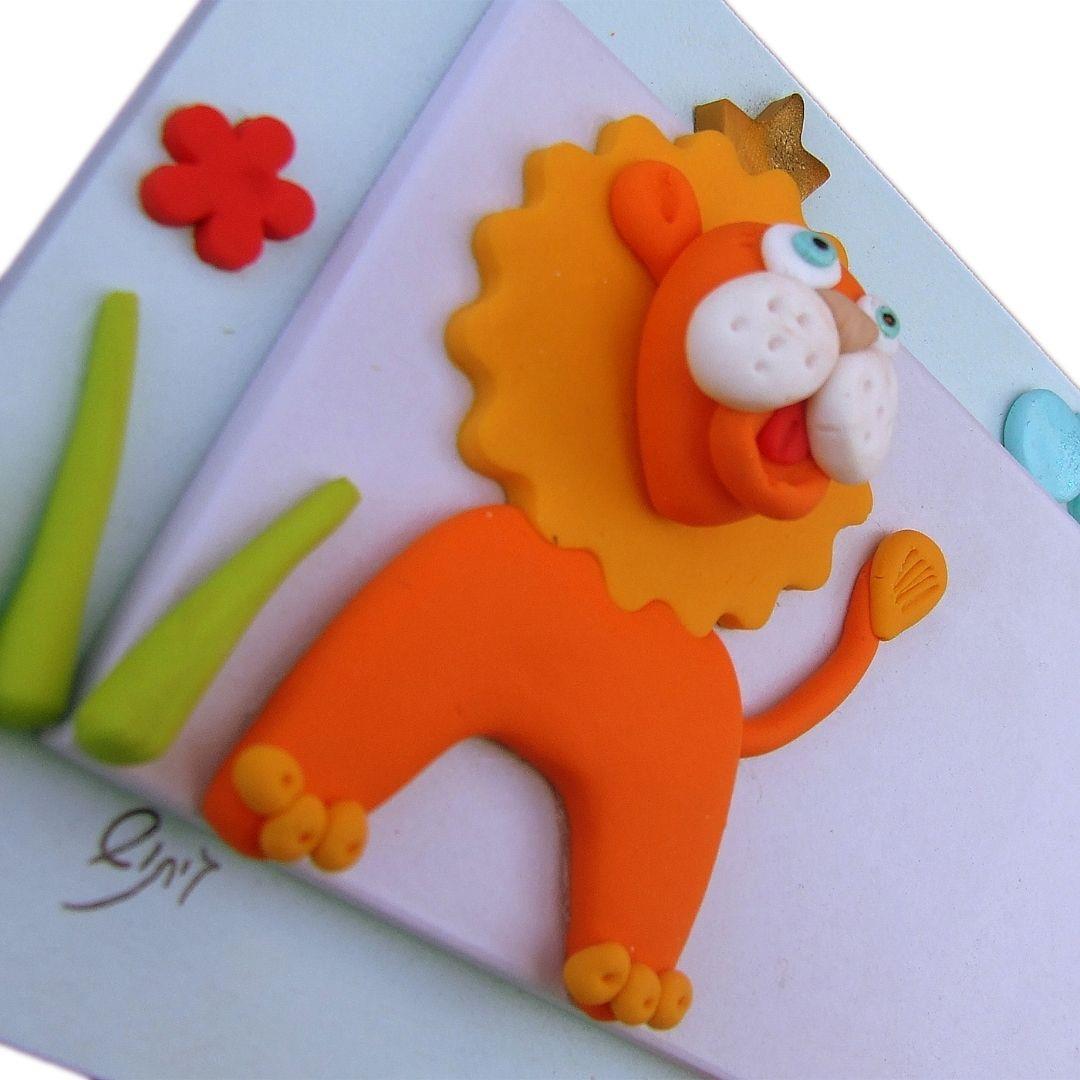 תקריב על עבודת הפיסול בחימר פולימרי (פימו) של אריה ופרחים בשלט עץ מבית גיתוש. תקריב על עבודת הפיסול בחימר פולימרי (פימו) של אריה ופרחים בשלט עץ מבית גיתוש.